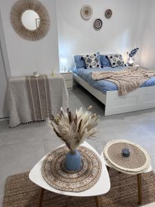 Sala de estar con cama y mesa con jarrón en Estudio coqueto con Terraza, en Alicante