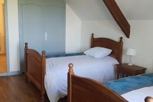 sypialnia z 2 łóżkami i stołem z lampką w obiekcie Maison de campagne en Périgord noir w mieście Nadaillac