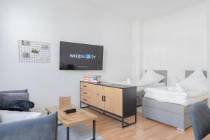 uma sala de estar com uma televisão e um sofá em Modernes Apartment 4 Personen Zentral 56qm WLAN gehobene Ausstattung em Hanôver