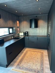 a kitchen with a counter and a sink and a rug at Stylish cabin at Lifjell with jacuzzi and sauna in Bø