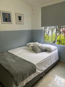 Ce lit se trouve dans un dortoir doté d'une fenêtre. dans l'établissement Casa amoblada lista para estrenar, à Cali