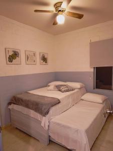 - 2 lits dans une chambre avec un ventilateur de plafond dans l'établissement Casa amoblada lista para estrenar, à Cali