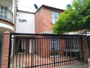 une clôture noire devant une maison dans l'établissement Casa amoblada lista para estrenar, à Cali