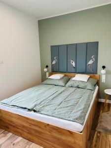 une chambre avec un grand lit et une tête de lit bleue dans l'établissement Apartamenty Dębowa 10, à Milicz