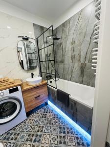a bathroom with a tub and a sink at Apartamenty Dębowa 10 in Milicz