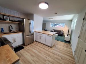 a kitchen and living room with a refrigerator freezer at Updated Douglas Apartment, Close to Sandy Beach in Juneau