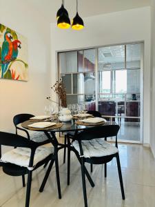 a dining room with a black table and chairs at Bienvenue au centre-ville de Libreville in Libreville