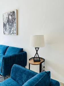 a living room with two blue couches and a lamp at Bienvenue au centre-ville de Libreville in Libreville