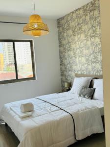 a bedroom with a large white bed with a wall at Bienvenue au centre-ville de Libreville in Libreville
