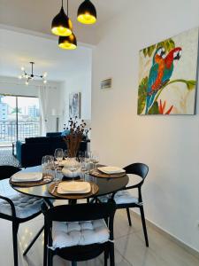a dining room with a table with chairs and a painting at Bienvenue au centre-ville de Libreville in Libreville
