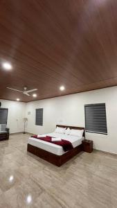 a bedroom with a large bed with a wooden ceiling at Paithal village Homestay in Paithalmala