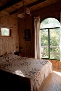 ein Schlafzimmer mit einem Bett und einem großen Fenster in der Unterkunft Luna Vieja in Tigre