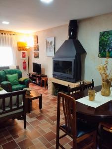 a living room with a fireplace and a green couch at Vivienda Rural Ronda in Aldeaquemada