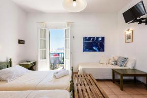 Pokój z 2 łóżkami, telewizorem i oknem w obiekcie Zanneta's House w mieście Nausa