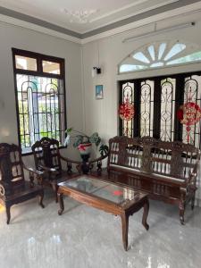 a living room with a table and chairs and stained glass windows at Cle homestay in Hue
