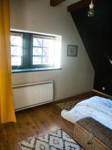 a bedroom with a bed and a window at Gite Traditionnel au Centre Historique d'Éguisheim in Eguisheim