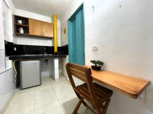a kitchen with a wooden table and a wooden chair at APARTAHOTEL BACANO LOFT in Santa Marta