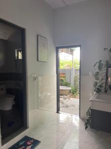 a bathroom with a toilet and a door to a courtyard at Cle homestay in Hue