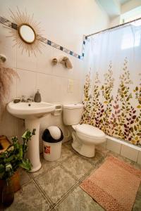 uma casa de banho com um WC, um lavatório e uma cortina de chuveiro em Blue Lotus Retreat Center em Písac