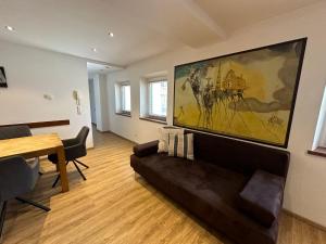ein Wohnzimmer mit einem Sofa und einem Gemälde an der Wand in der Unterkunft Appartement Kramerhaus in Hollersbach im Pinzgau