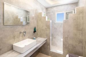 a bathroom with a sink and a shower at Windmillside Luxury Villas in Emporio