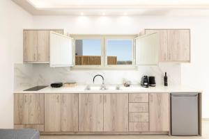 a kitchen with wooden cabinets and a sink at Windmillside Luxury Villas in Emporio