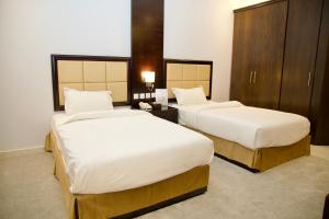 two beds in a hotel room with white sheets at فندق أصداء الراحة Asdaa Alraha Hotel in Jeddah