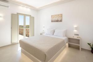 una camera bianca con un letto e una finestra di Windmillside Luxury Villas a Emporio