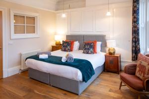 a bedroom with a large bed and a chair at The Fig Tree Markinch, Glenrothes in Markinch