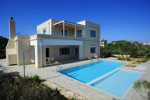 a house with a swimming pool in front of it at Villa Aeriko in Kounoupidhianá