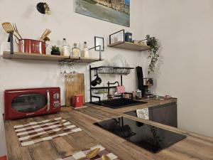 uma cozinha com um micro-ondas vermelho numa mesa de madeira em La Barbera's apatments old town PA em Palermo