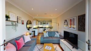 un soggiorno con divano e TV di Madison Hill - White Hill House 4 - 2 bedroom flat a Londra