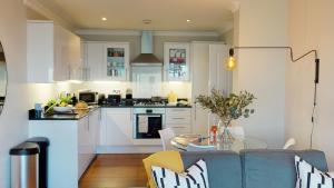 una cucina con divano e tavolo in una camera di Madison Hill - White Hill House 4 - 2 bedroom flat a Londra