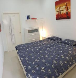 a bedroom with a bed with a blue comforter at El Faro del Manteca in Cádiz