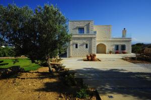 a large stone house with a tree in front of it at Villa Aeriko in Kounoupidhianá