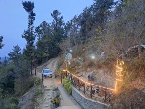a car is parked on a hill with lights at HILL WOOD CAMP in Shimla