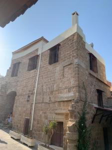 un antiguo edificio de ladrillo con una torre en Suite del Capitano, en Rodas