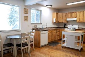 uma cozinha com armários de madeira, uma mesa e um lavatório em Ocean and Mountain View Home, near Downtown Juneau em Juneau