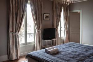 ラ・フェルテ・スー・ジュアールにあるWaterfront Manoir near Paris, Champagne and Disneyのベッドルーム(ベッド1台、テレビ、窓付)