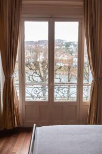 ラ・フェルテ・スー・ジュアールにあるWaterfront Manoir near Paris, Champagne and Disneyのベッドルーム1室(ベッド1台、大きな窓付)