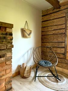 a room with a chair and two baskets on the floor at PLŪSME Restart House in Lielstraupe