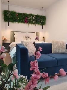 a living room with a blue couch and flowers at Premium Hils Brauner Studio in Bucharest +42 photos