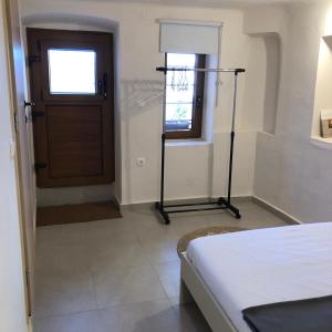 1 dormitorio con 1 cama y puerta de madera en Solo traveler, en Ermoupoli