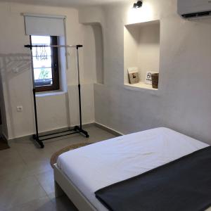 1 dormitorio con cama, ventana y espejo en Solo traveler, en Ermoupoli