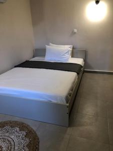 Un dormitorio con una cama con una almohada blanca. en Solo traveler, en Ermoupoli