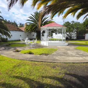 a gazebo with tables and chairs in a park at Casa Hamilton casa entera in Cuenca