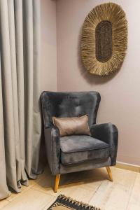 una sedia in pelle con cuscino in una stanza di Casa Blue Hotel, Philian Hotels and Resorts a Città di Skiathos
