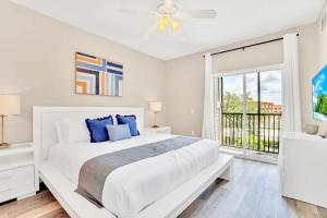 ein weißes Schlafzimmer mit einem großen Bett und einem Fenster in der Unterkunft Near Disney - 2BR Condo - Balcony Pool Hot Tub in Orlando