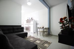 a living room with a couch and a table and a kitchen at Casa Novo in Olímpia