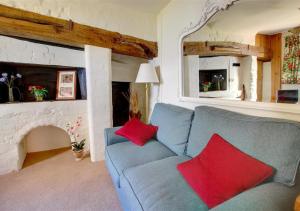sala de estar con sofá azul y almohadas rojas en Half Moon Inn en Aylsham